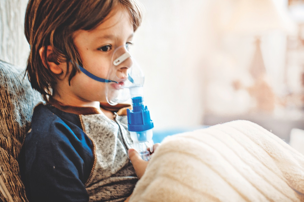 Child holds a mask vapor inhaler