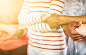 Together We Can Creative team meeting hands together in line. Young people in casual clothes are holding hands. Unity and teamwork concept.