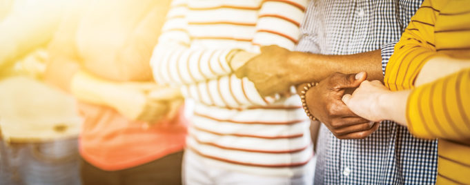 Together We Can Creative team meeting hands together in line. Young people in casual clothes are holding hands. Unity and teamwork concept.