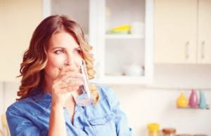Are You Drinking Enough Water? woman drinking a glass of water