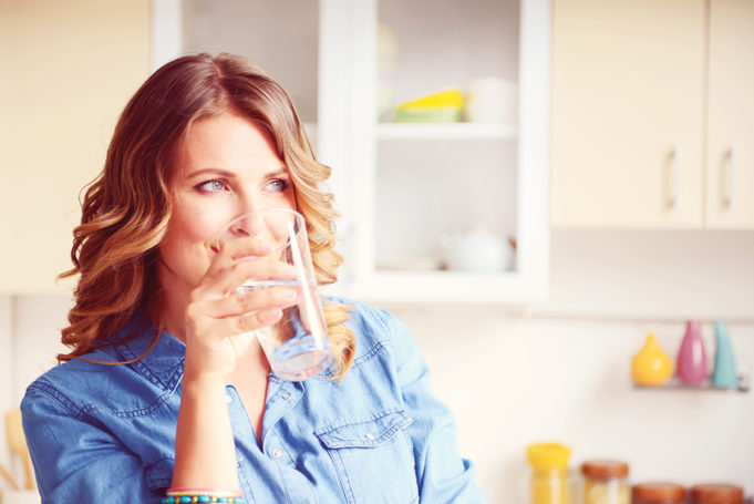 Are You Drinking Enough Water? woman drinking a glass of water
