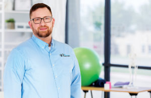 Leaders of Cobb: Ted Ziaylek Cheerful mid adult physical therapist smiles confidently in a gym. She is holding hand weights.