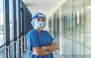 Local Nursing Leaders Enhance Healthcare In Georgia portrait of a young nurse in a blue uniform and a protective shield to protect against a new dangerous virus covid19