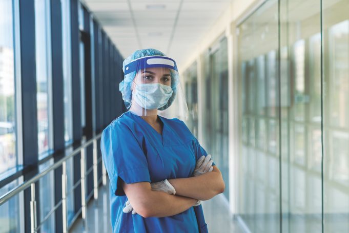 Local Nursing Leaders Enhance Healthcare In Georgia portrait of a young nurse in a blue uniform and a protective shield to protect against a new dangerous virus covid19