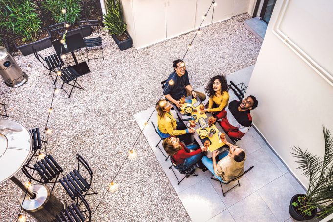 Post-Pandemic Most-Wanted High angle top view of happy friends drinking cocktails and having fun at restaurant garden party - Food and beverage concept with young people together at home patio - Dark warm filter