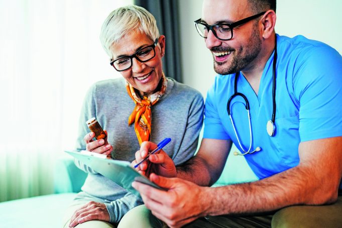 Don’t Recover From Surgery Alone Young smiling doctor is consulting a modern senior woman - patient, on the visit at home