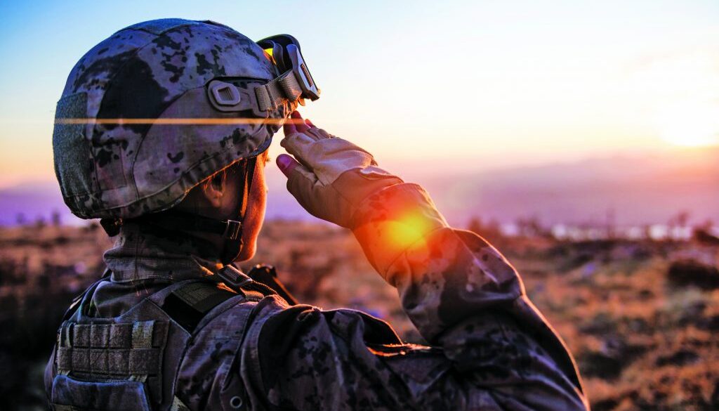Female Army Solider Saluting against sunset sky