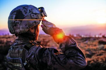 Female Army Solider Saluting against sunset sky