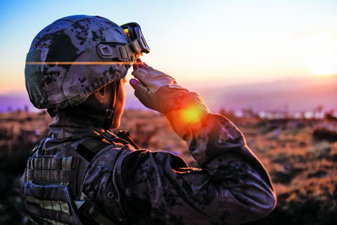 Honoring Military Veterans Female Army Solider Saluting against sunset sky