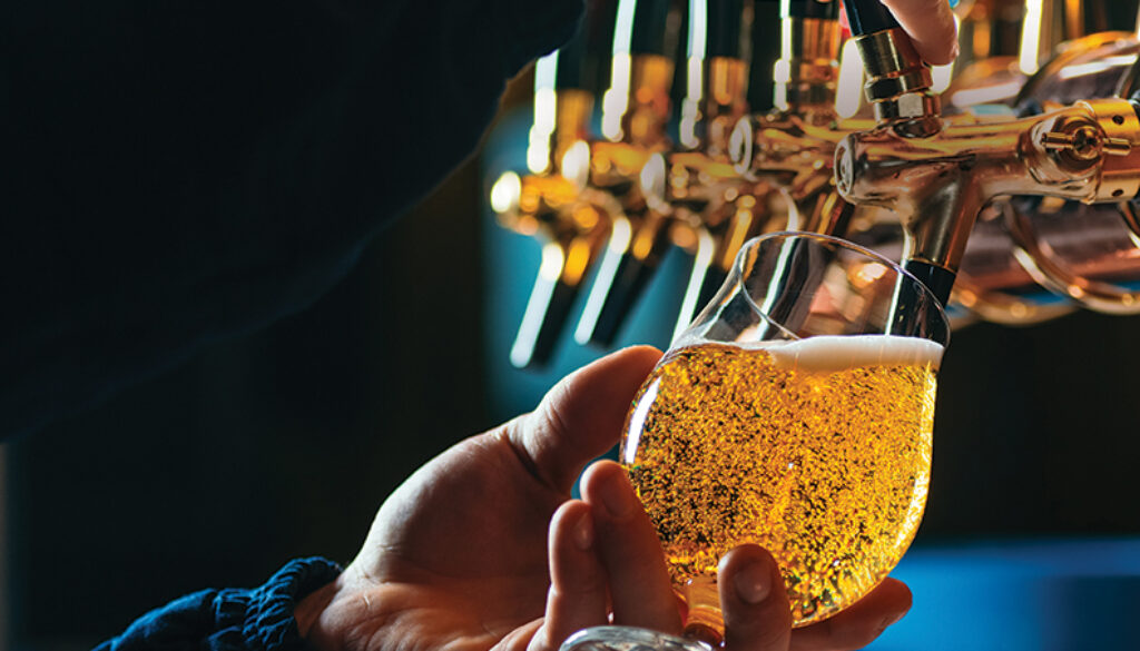Close up of bartender pouring draft beer in glass