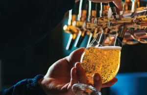 Bubbles & Brews Close up of bartender pouring draft beer in glass