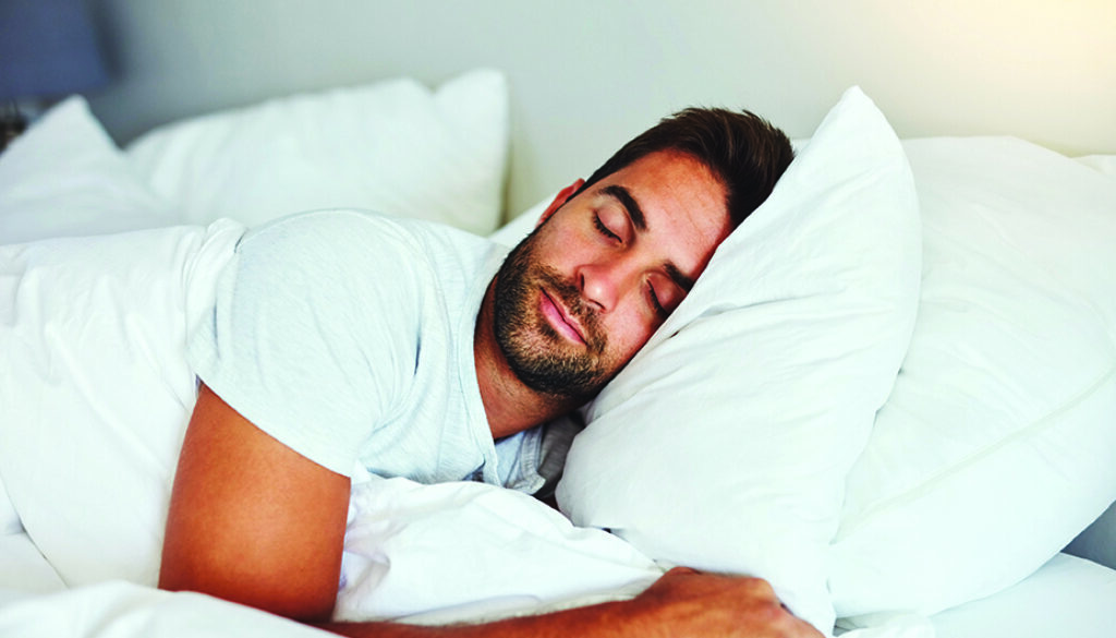 Cropped shot of a handsome young man sleeping comfortably in his bed at home