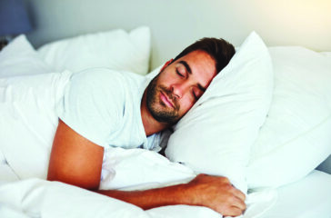 Cropped shot of a handsome young man sleeping comfortably in his bed at home