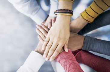 Close up top view of young business people putting their hands together. Stack of hands. Unity and teamwork concept.