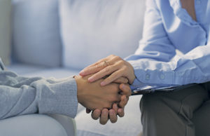 Help, Hope, Healing Mental health, therapy and support, women holding hands on sofa in counselling for stress, anxiety and help. Empathy, advice and compassion, psychologist in office with patient working on problem.