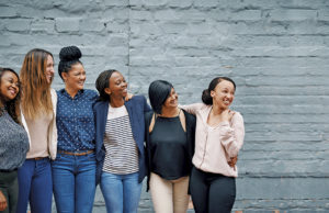 A Story Of Hope, Community & Resilience Shot of a diverse group of young women standing together against a gray wall outside