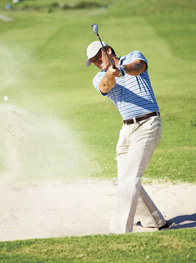 Golf Is A Win-Win! Professional golf player chipping the ball from the sand bunker