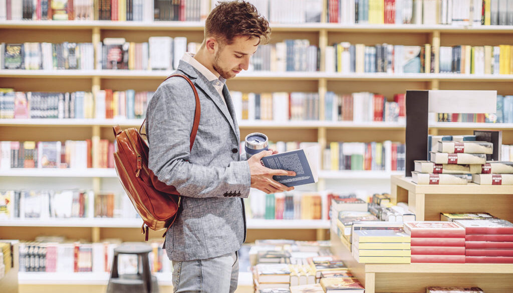Man looking through a book in a bookstore
