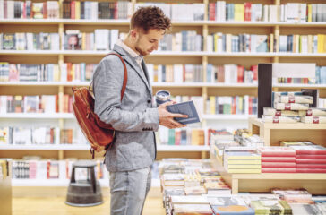 Man looking through a book in a bookstore