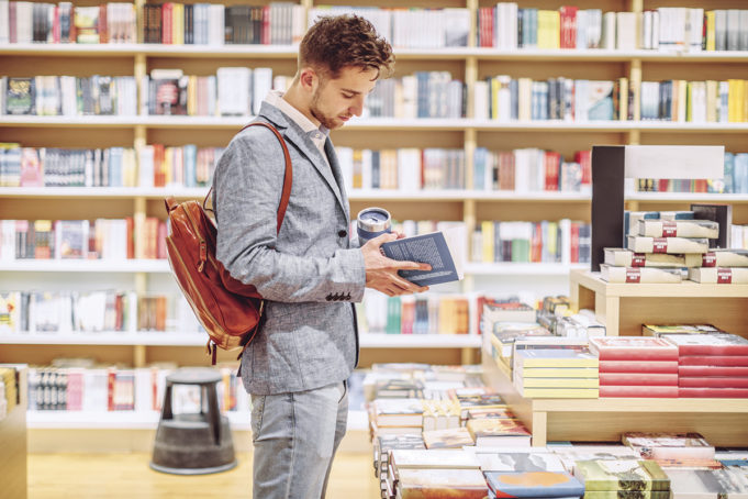 A Novel Approach To My Mornings Man looking through a book in a bookstore