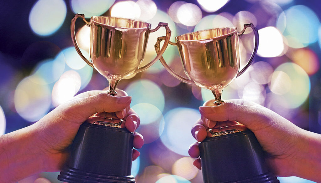 Two winners show trophy with abstract bokeh light background