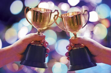 Two winners show trophy with abstract bokeh light background