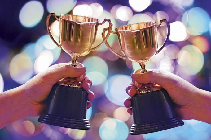 Cobb’s Citizens & Businesses of the Year Two winners show trophy with abstract bokeh light background