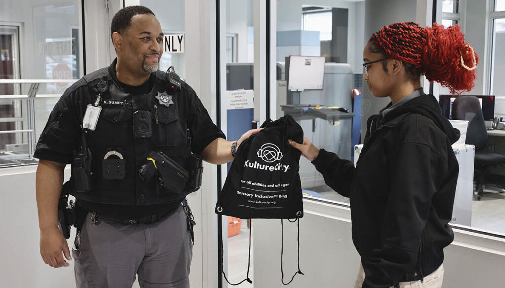 Student receives a KultureCity sensory bag from deputy.