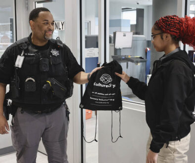 Student receives a KultureCity sensory bag from deputy.