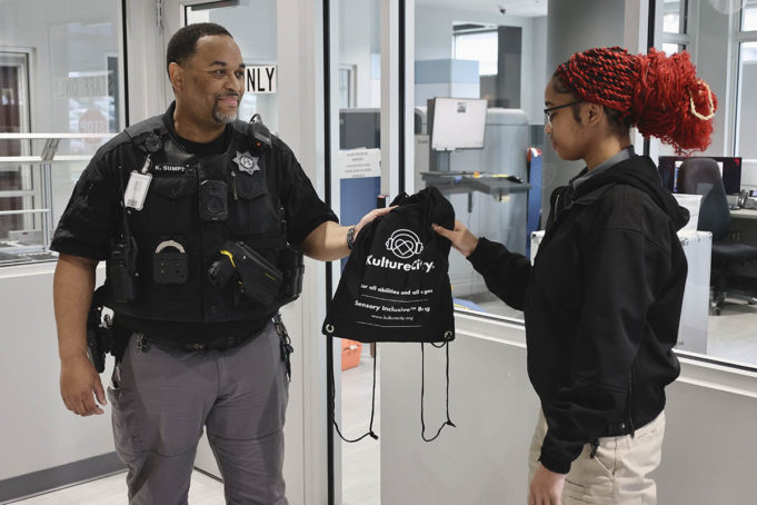 Breaking Barriers Student receives a KultureCity sensory bag from deputy.
