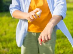Battling Mosquitoes Mosquito repellent. Woman using insect repellent spray outdoors. High quality photo