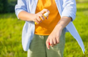 Battling Mosquitoes Mosquito repellent. Woman using insect repellent spray outdoors. High quality photo