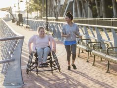 How Walkability and Movability Can Impact People, Place, and Prosperity in Cobb County Two friends exercising along a city waterfront. The young woman in the wheelchair has spina bifida. Her friend jogging beside her and talking is a mid adult Hispanic woman in her 30s.