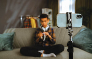Using Social Media This Summer? Young Person Recording a Video at Home with Smartphone