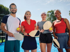 A Practical Guide To Hosting A Charity Pickleball Tournament Group of happy athletic friends playing mixed doubles in pickleball and looking at camera.